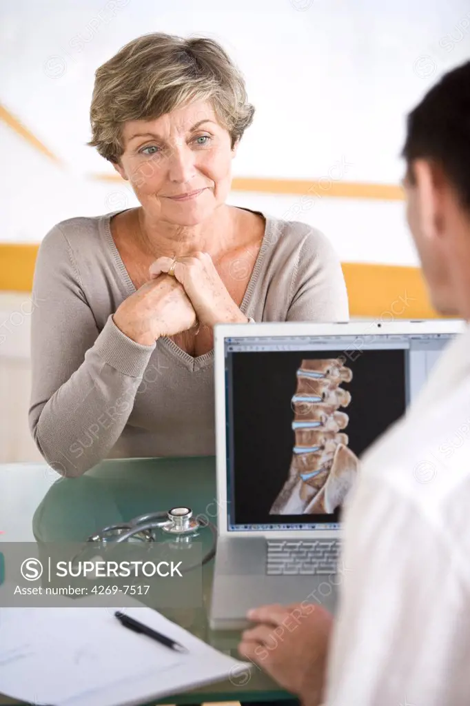 Doctor discussing backbone 3D CT scan with a patient.