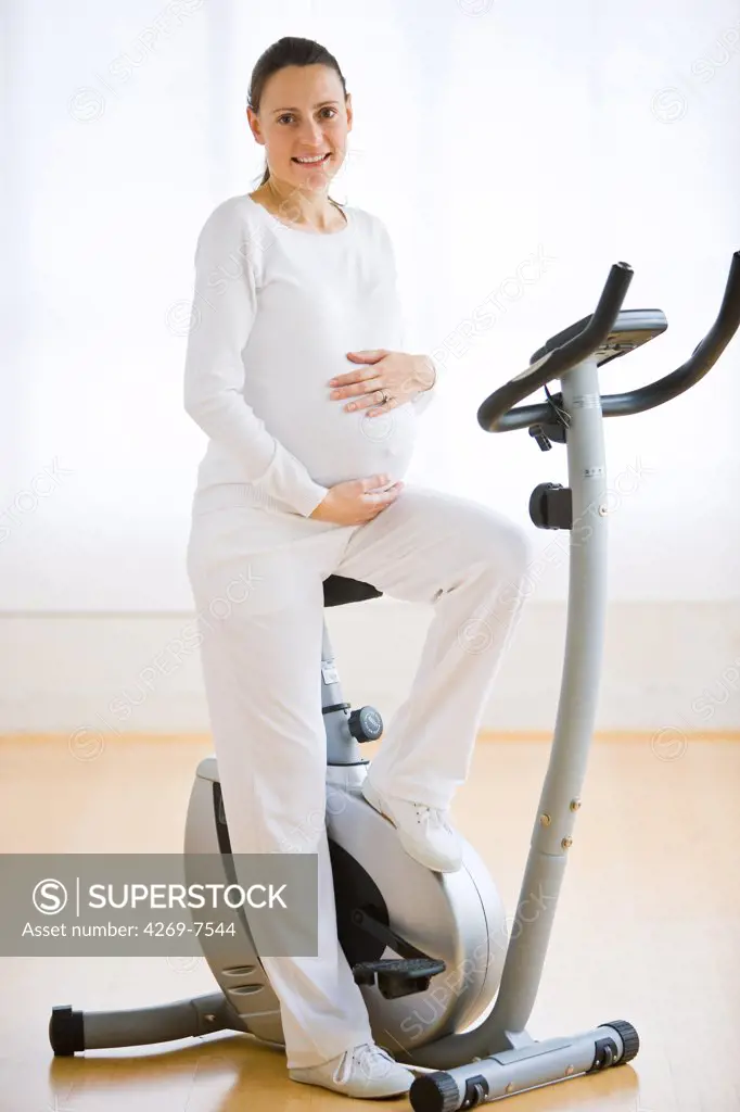 Pregnant woman with exercise bicycle.