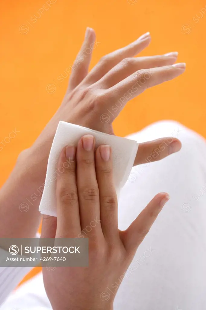 Woman applying gauze compress on her hand.