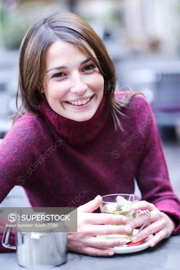 Woman drinking hot beverage.