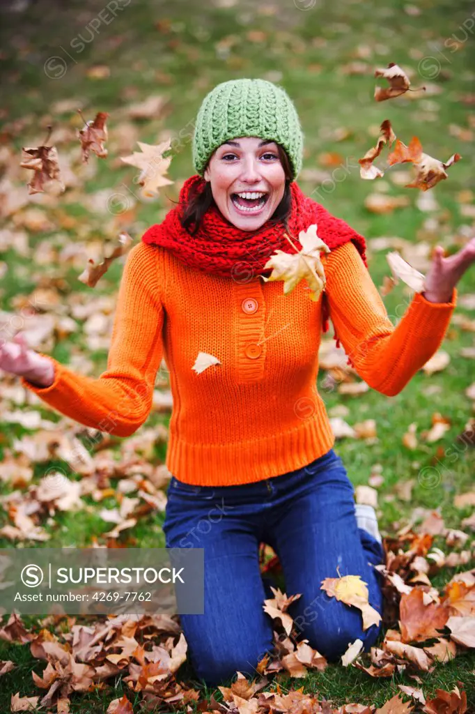 Woman with dead leaves in autumn.