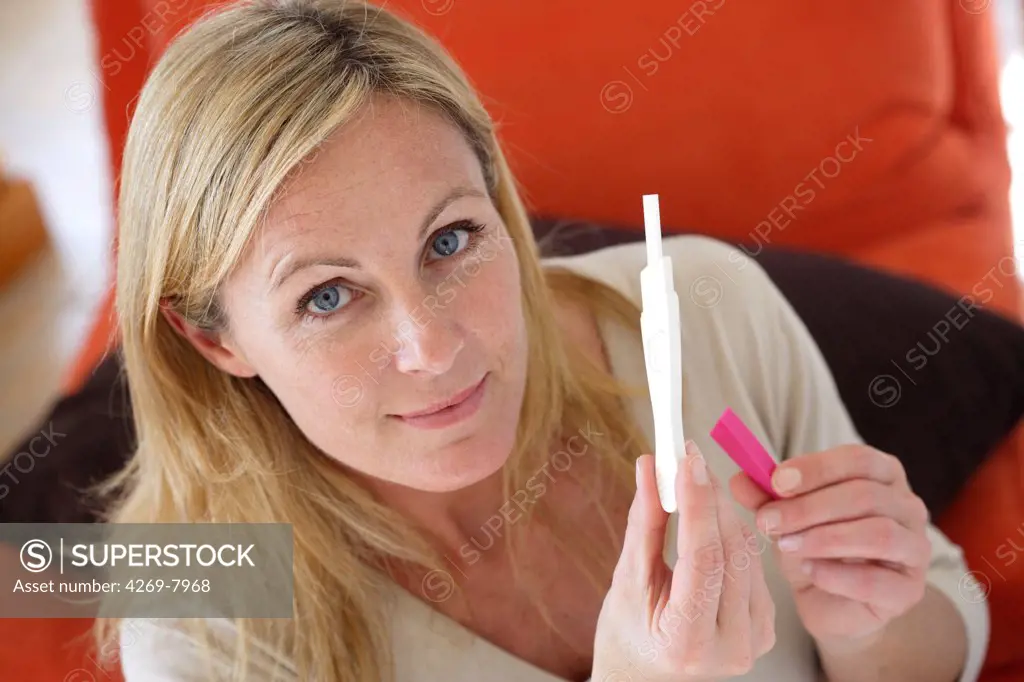 Woman reading a pregnancy test.