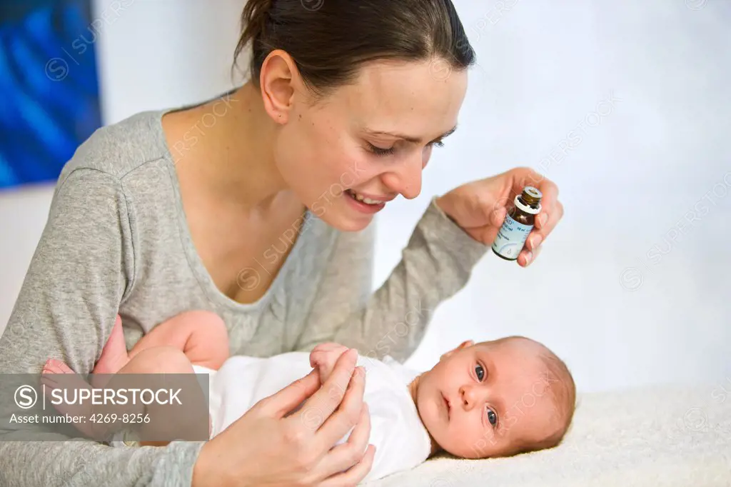 A mother is giving drops of vitamin D to her one month old baby.