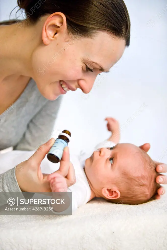 A mother is giving drops of vitamin D to her one month old baby.