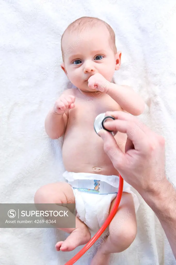 Pediatrician examining 2 months old baby with a stethoscope.