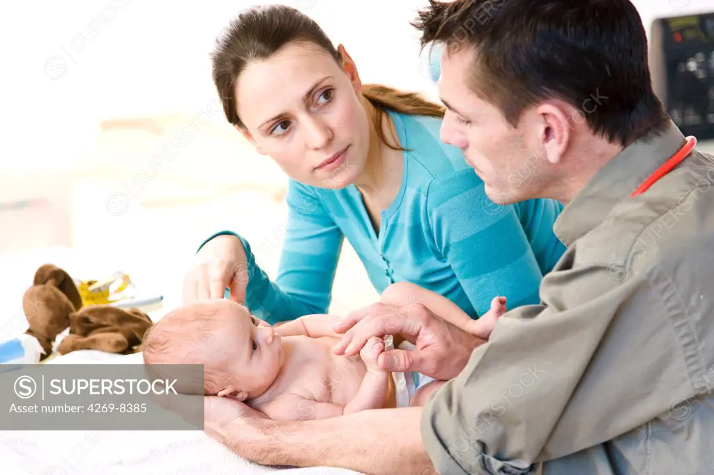 Doctor examining a 2 months old baby with her mother.