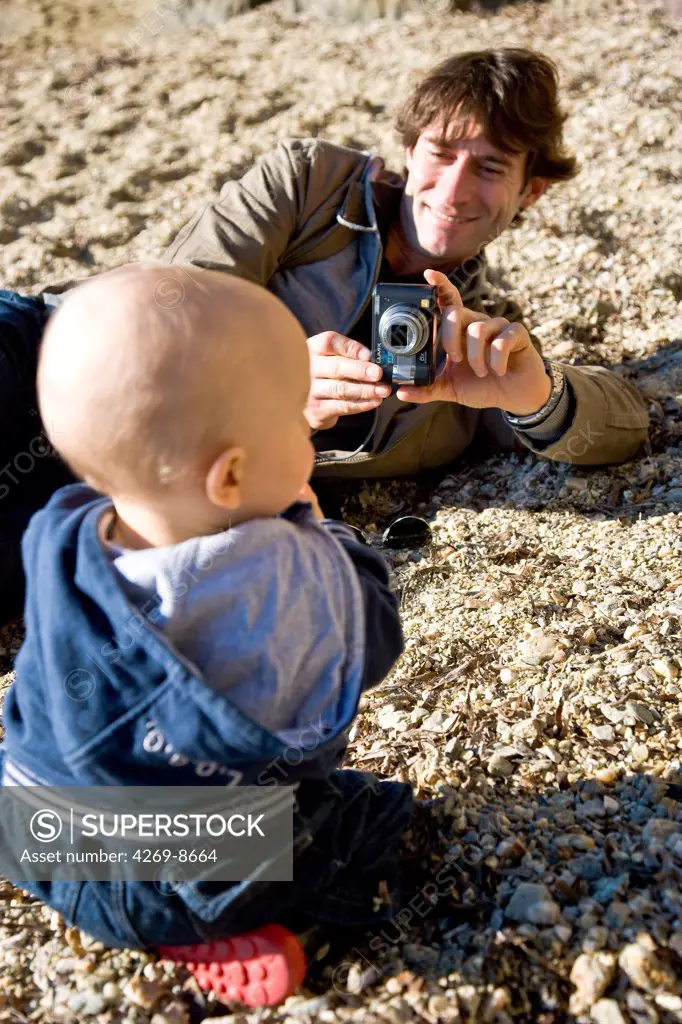 Father taking picture of his one year old baby.