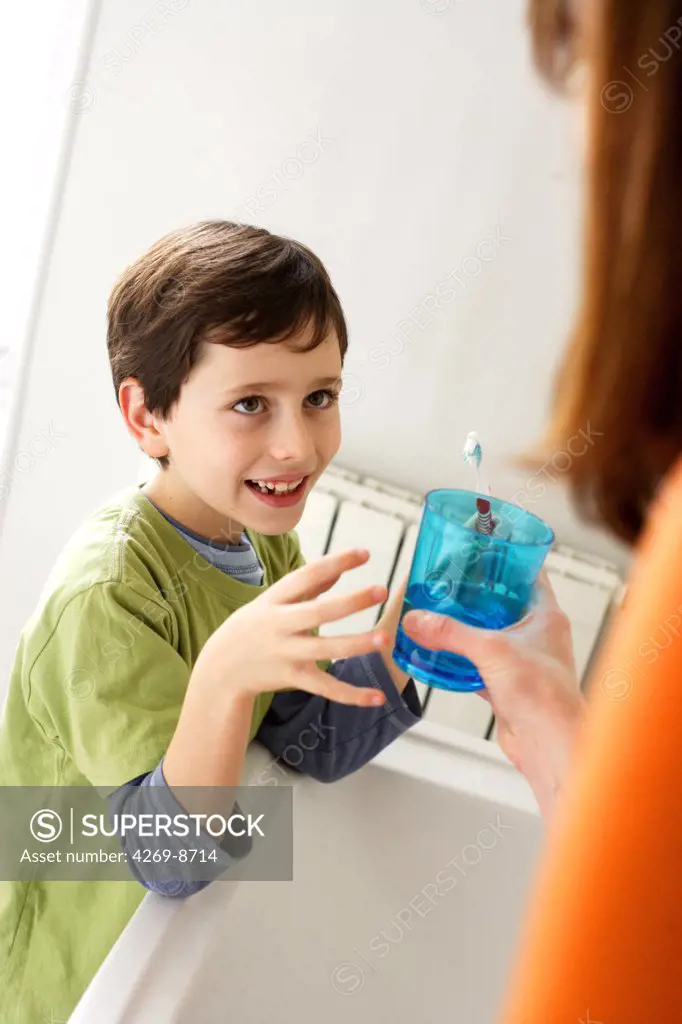 8 years old child brushing his teeth.