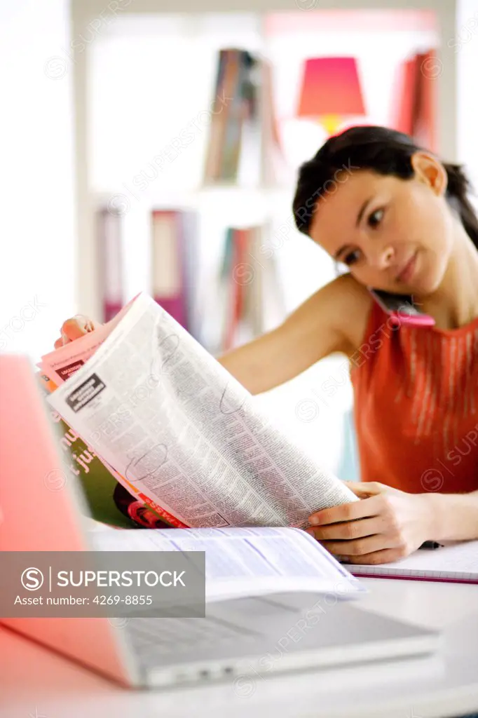 Woman reading newspaper classified ads.