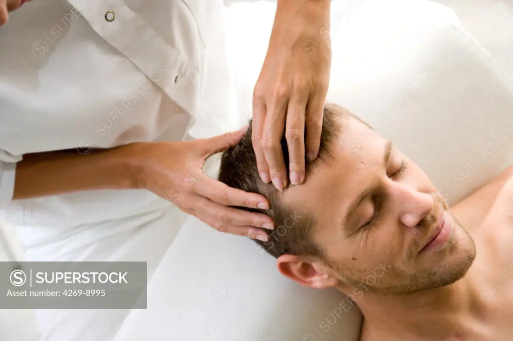 Man receiving a face acupressure massage : the pressure on acupuncture points stimulates enregy flow and releives stress.
