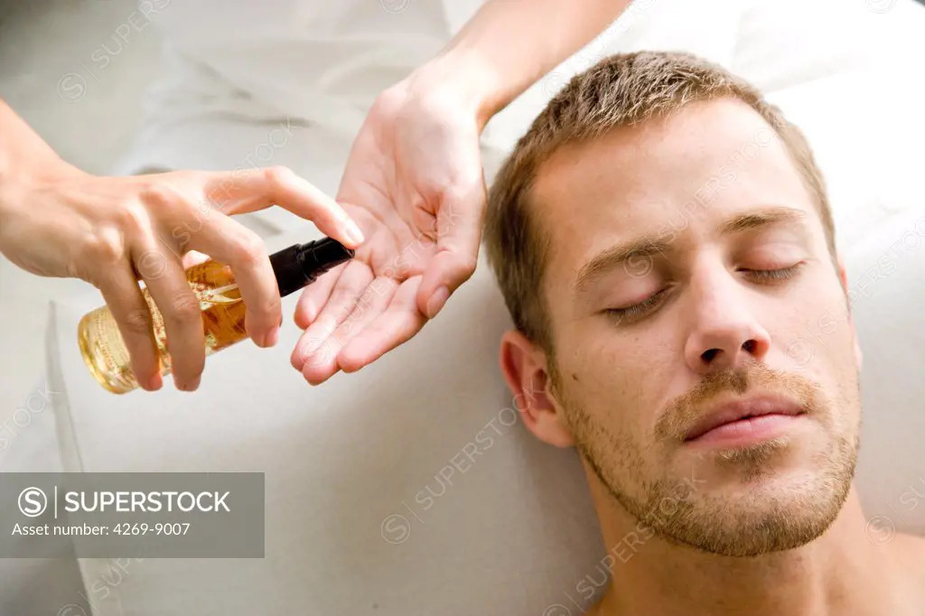 Man receiving oil face care.