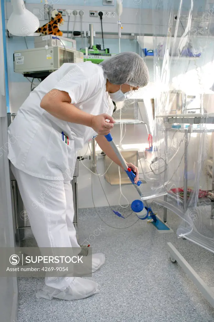 Hospital staff cleaning the floor of sterile unit. Department of Haematology and Immunology, Limoges hospital, France.