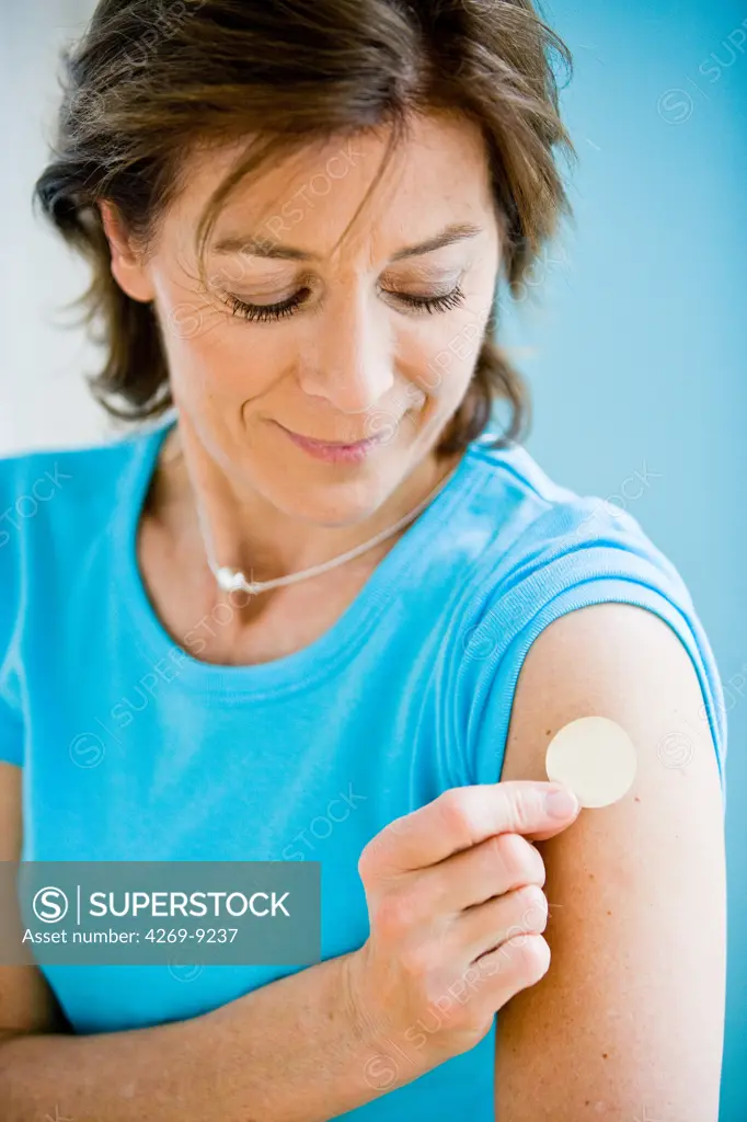 Woman applying a patch.
