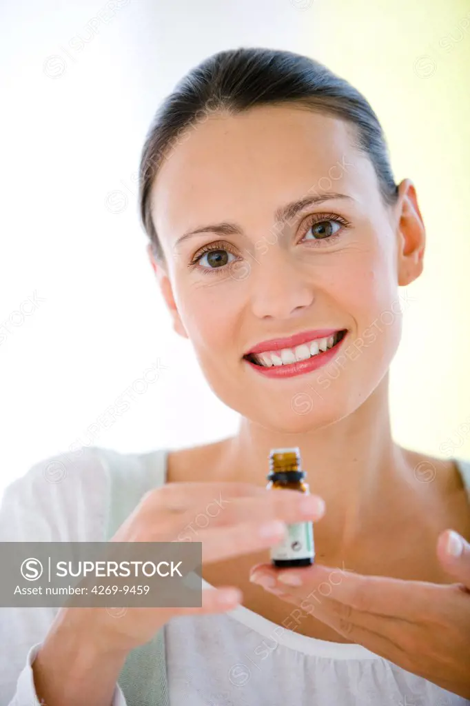 Woman holding bottle of essential oils.