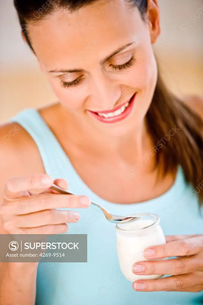 Woman eating a yogurt.