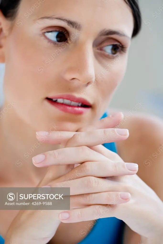 Portrait of woman with fingers crossed.