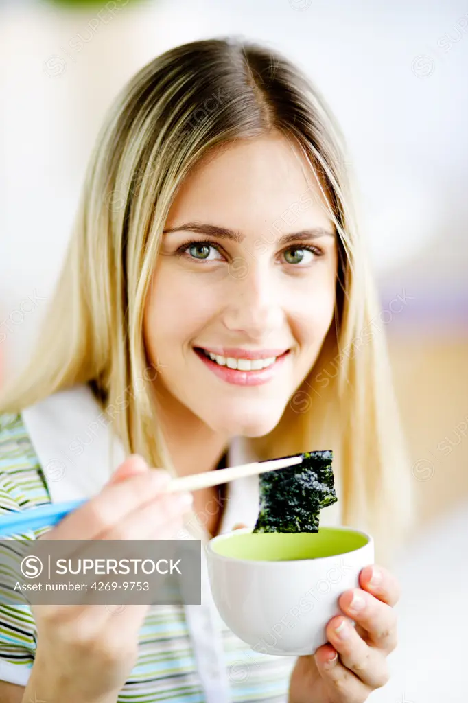 Woman eating edible seaweed.