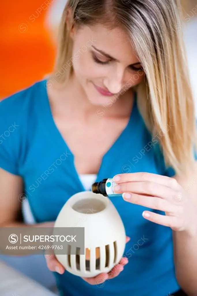 Woman using an essential oil diffuser.