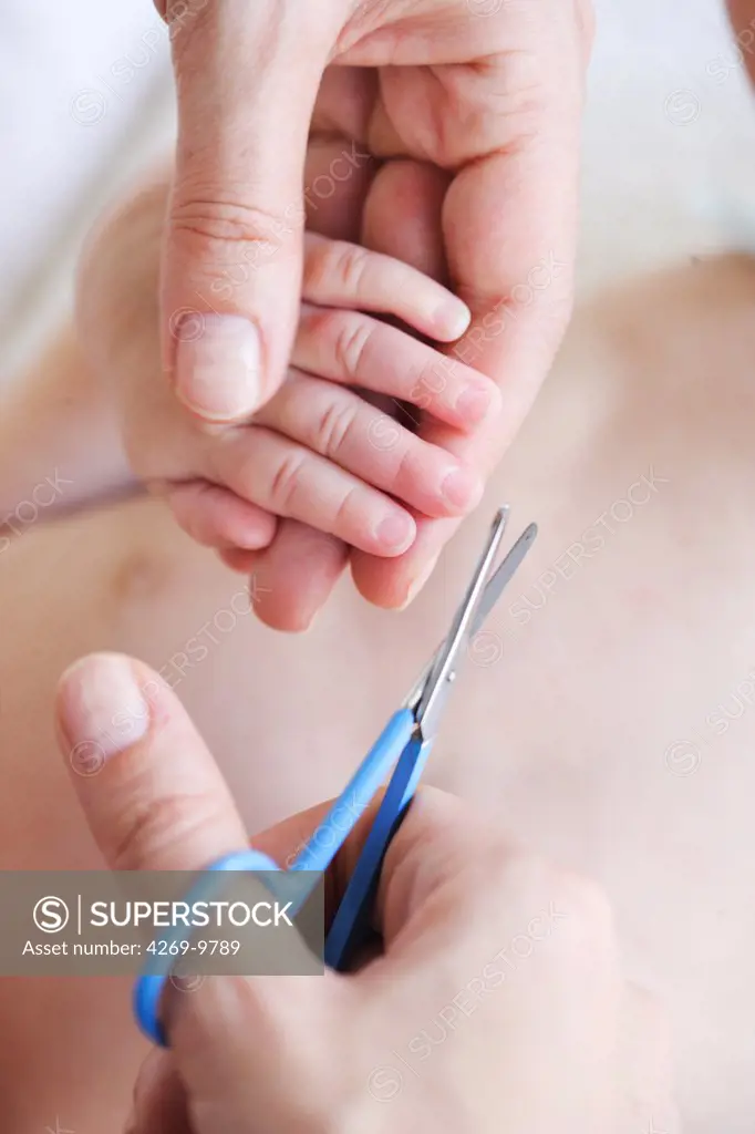 Baby having fingernails cut.