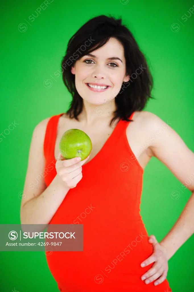 Pregnant woman eating an apple.