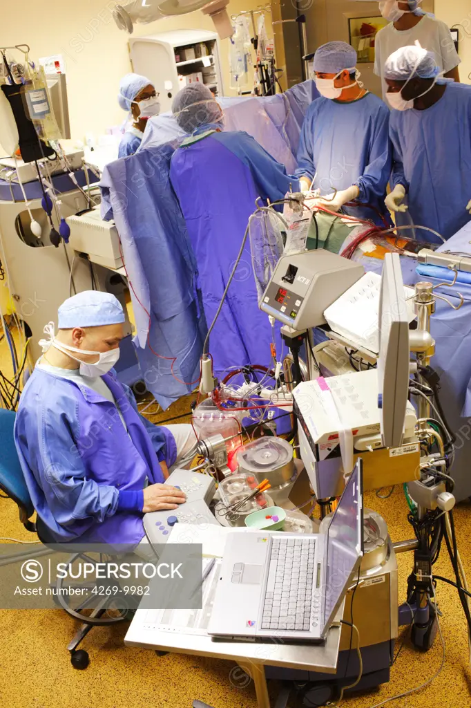 Anaesthesist at work during mitral valve replacement surgery, an open heart surgery requiring a cardiopulmonary bypass. Thoracic and Cardiovascular Surgery Department, Limoges hospital, France.