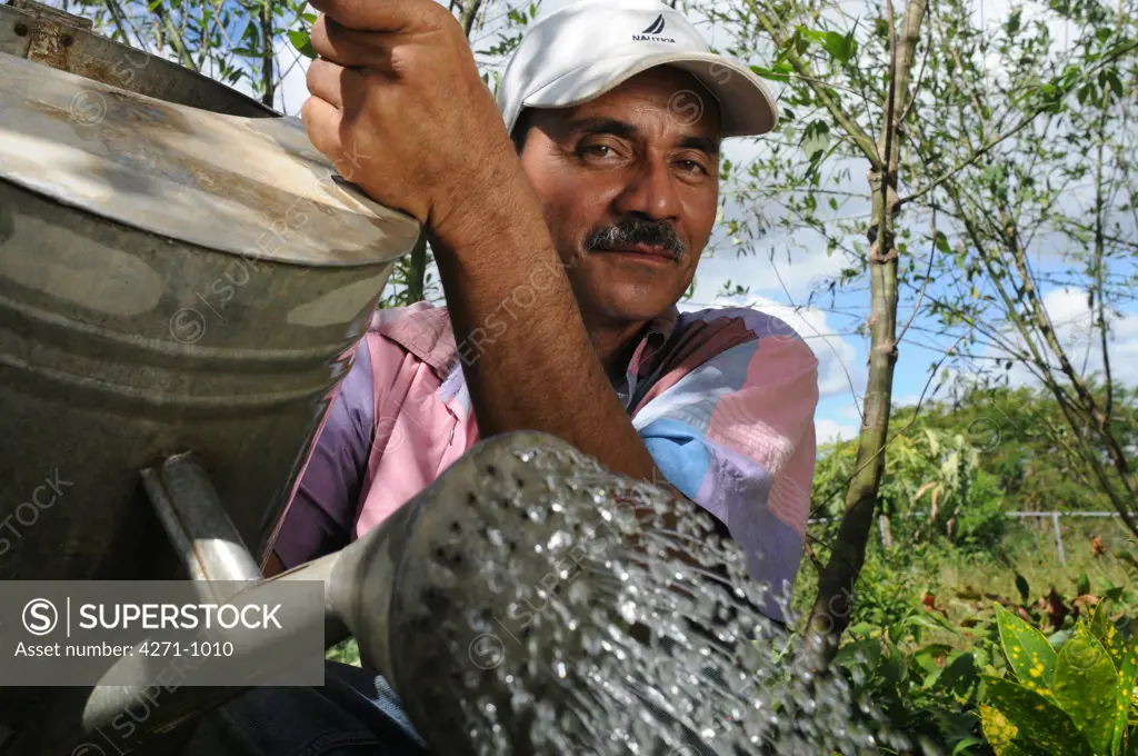 Nicaragua, Macuelizo, Portrait of farmer watering plants in the mountainous Nueva Segovia