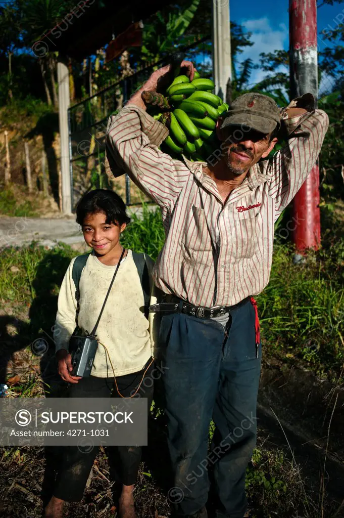 Nicaragua, Dipilto, Farmer carrying bananas with daughter in the mountainous Nueva Segovia
