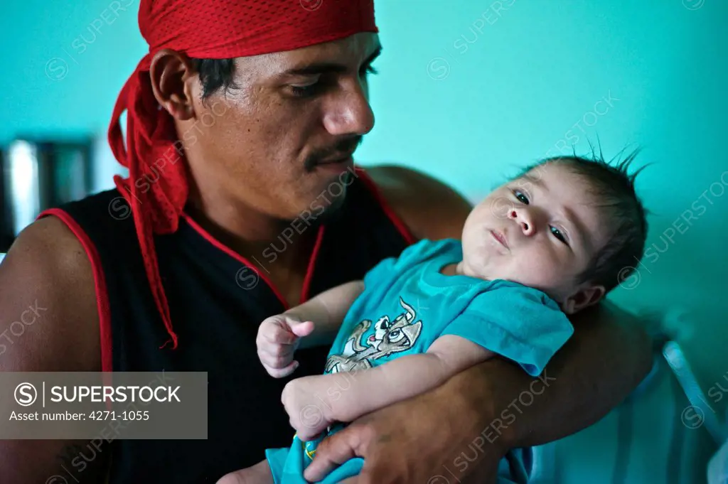 Nicaragua, Managua, Father holding baby boy at hospital near La Chureca Industrial waste disposal site