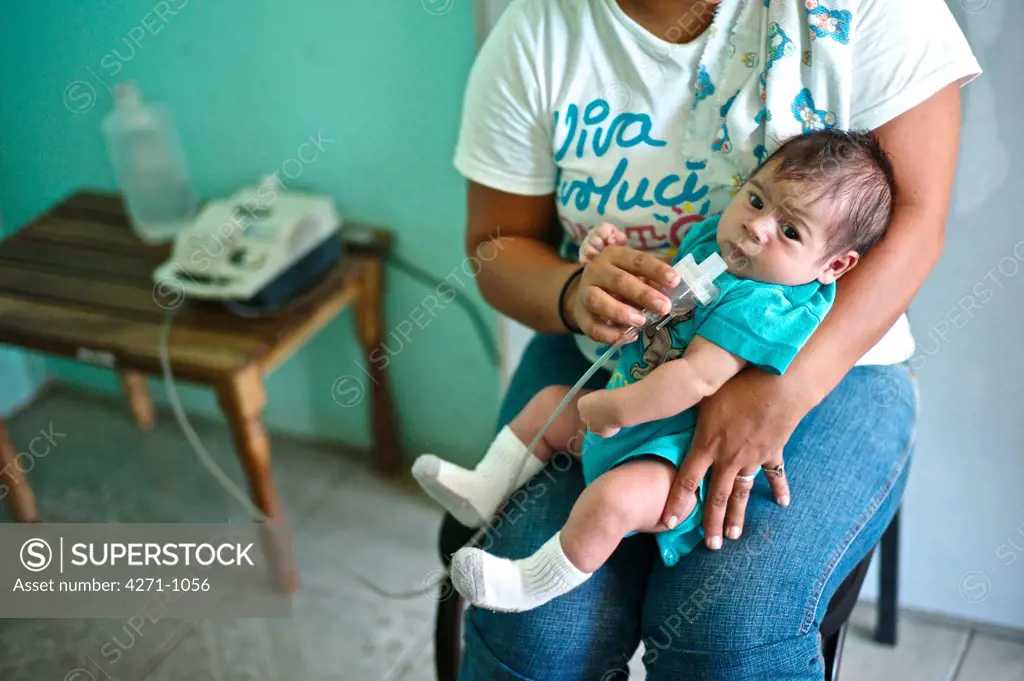 Nicaragua, Managua, Mother holding baby boy at hospital near La Chureca Industrial waste disposal site
