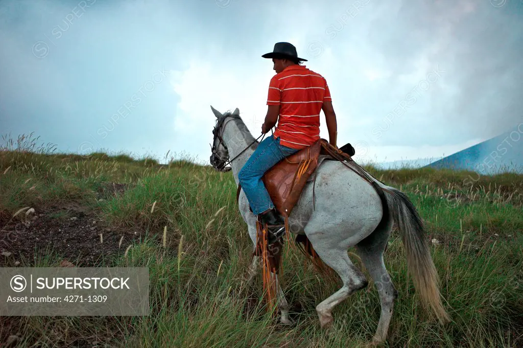 Nicaragua, Masaya Volcano National Park, Man riding horse in largest National Park by volcano crater