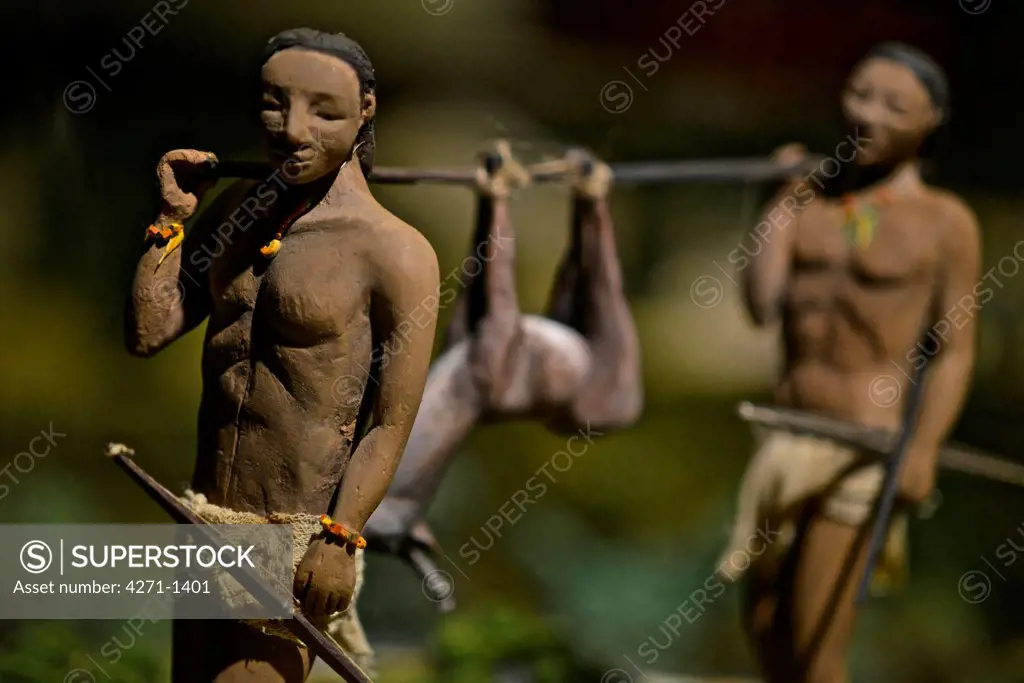 Costa Rica, San Jose, Pre-Columbian Gold Museum, Figurines of hunters carrying dead animal. Hunters carrying a dead animal. They used the animal as food, using the skins and bones as ornaments. Recreation of Pre-Columbian communities.