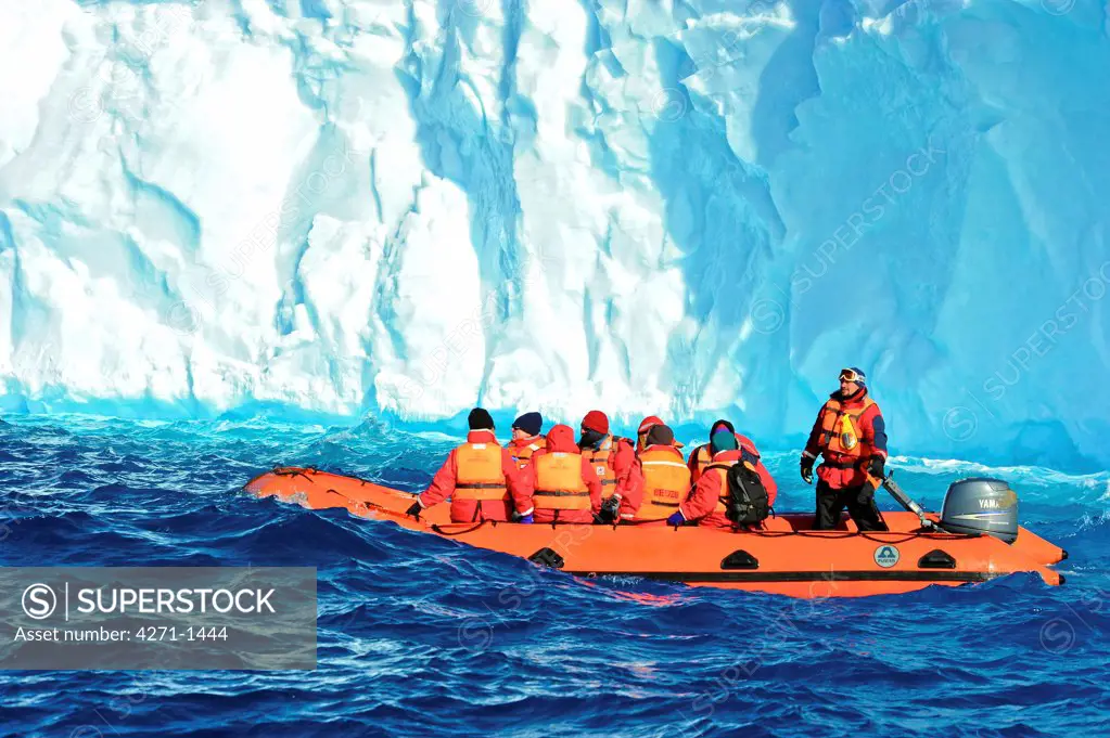 Antarctica, Portal Point, Tourist explore the icy water, passing in front of a blue iceberg