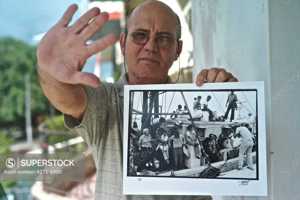 Cuba, Havana, Photographer holding photograph of Mariel migration