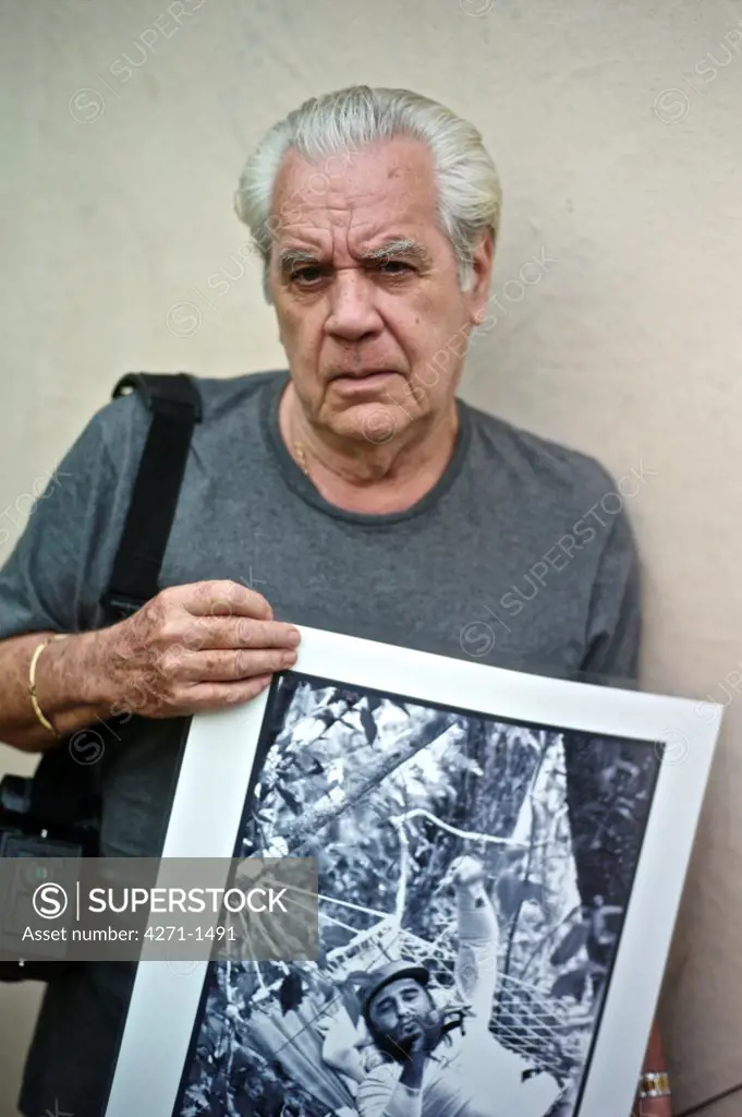 Cuba, Havana, Photographer with his works at his home