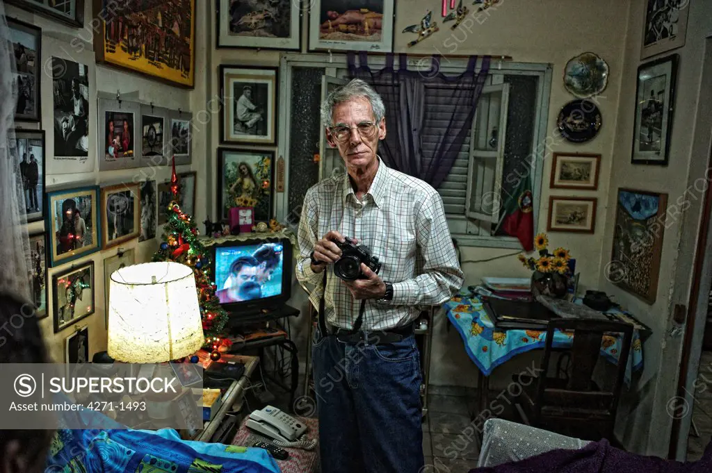 Cuba, Havana, Photographer holding his camera, at home