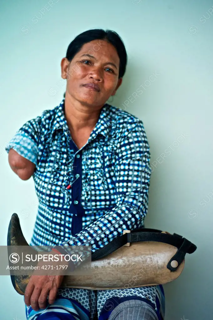 Portrait of a Cambodian land mine survivor lost an arm and a leg now using a prosthetic rudimentary wooden limb, Luang Phabang, Laos