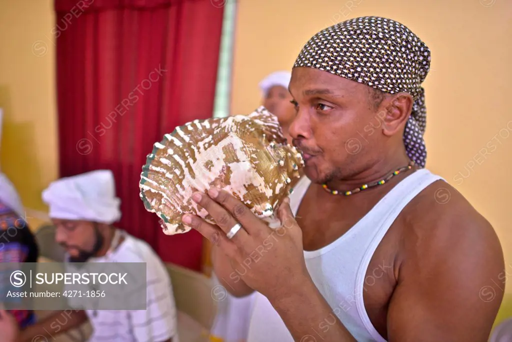 Garifuna playing the conch shell trumpet, the only wind instrument used today in Garifuna traditional music.The Garifuna,  descendants of Carib, Arawak, and West African people. The Garifuna music was proclaimed by UNESCO one of the masterpieces of the Oral and Intangible Heritage of Humanity in 2001.