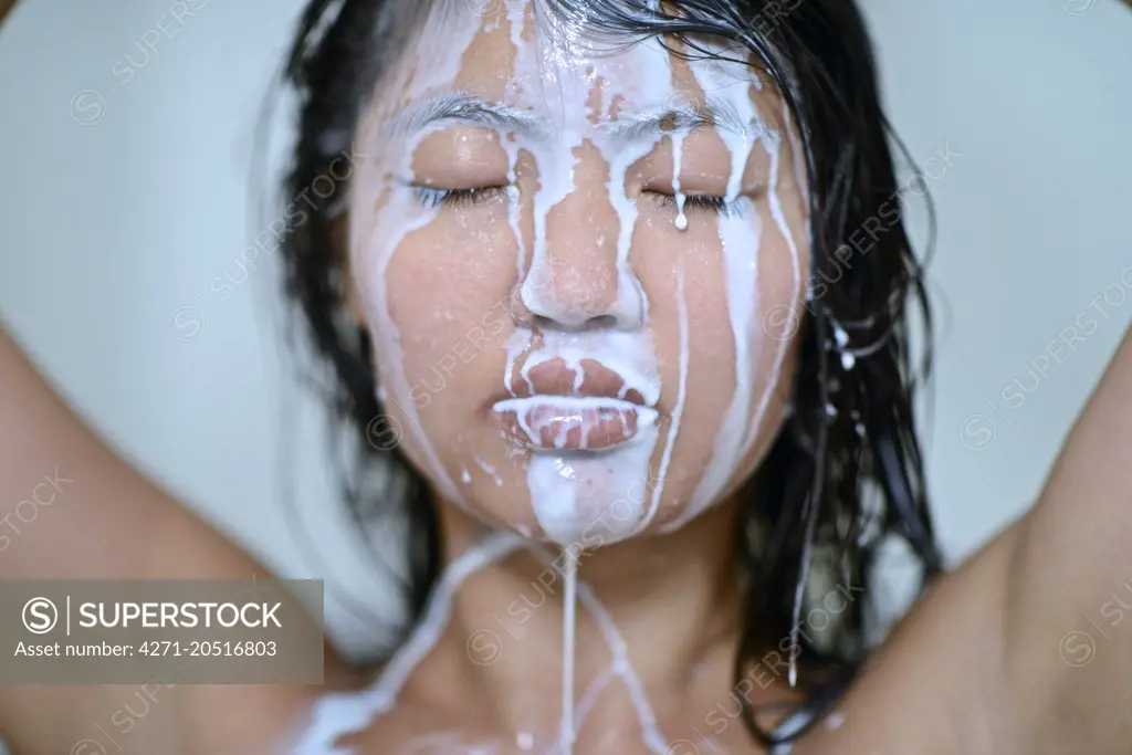 Milk pouring over a woman's face