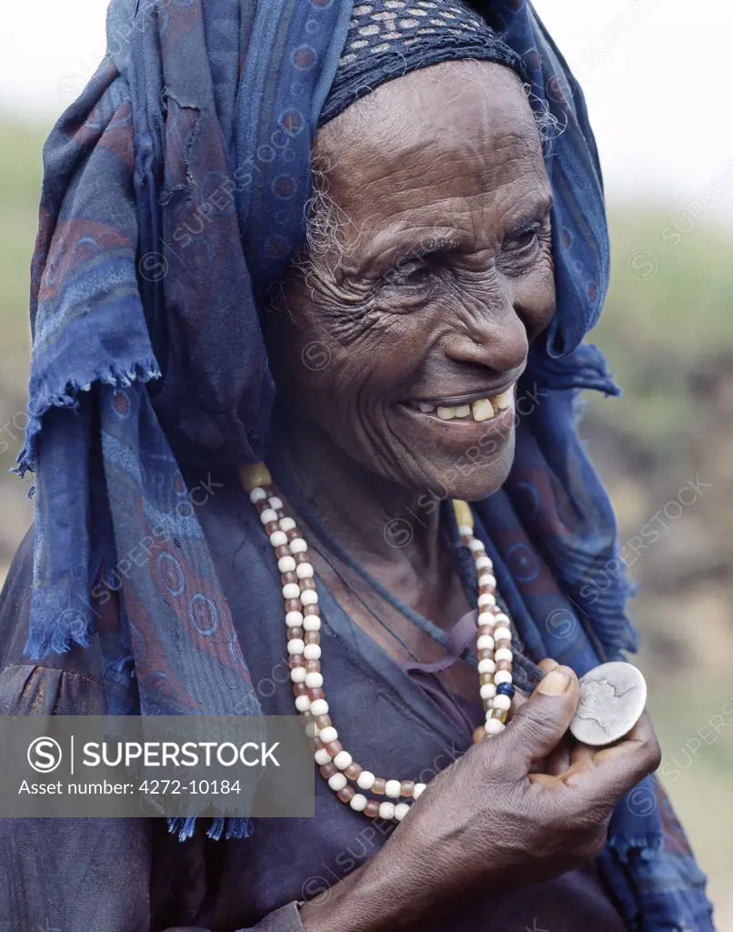 An Oromo old woman wears a necklace and a pendant made from a Maria Theresa thaler an old silver coin minted in Austria, which was widely used as currency in northern Ethiopia and Arabia until the end of World War II.