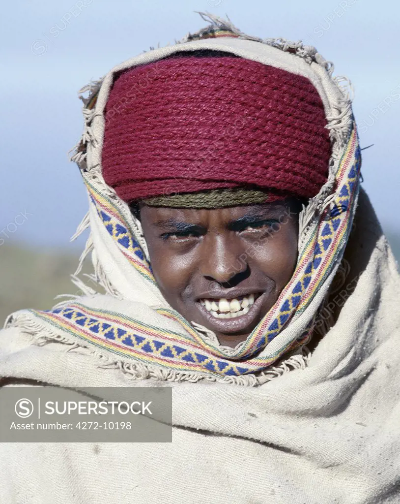 A young Amhara shepherd keeps well wrapped up against the cold mountain air on the western scarp of the Abyssinian Rift.  Here, at Gooch Meda, the scarp rises to over 11,000 feet above sea level.