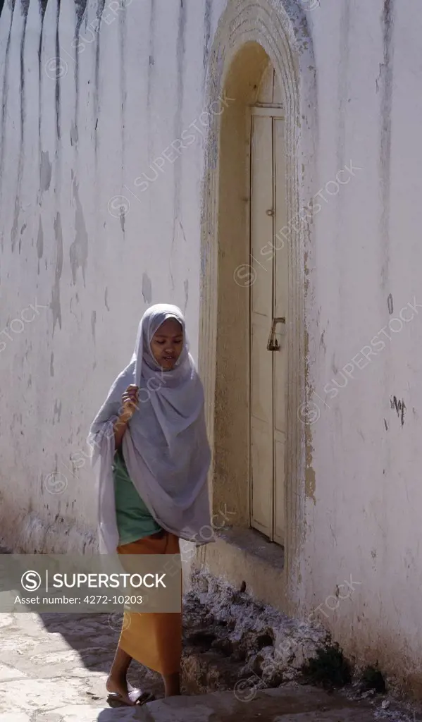 An Harari girl walks in a narrow cobblestone street of the medieval walled city of Harar.  Once an independent city-state dating back to the early 16th century, Harar was incorporated into the Ethiopian Empire in 1887.