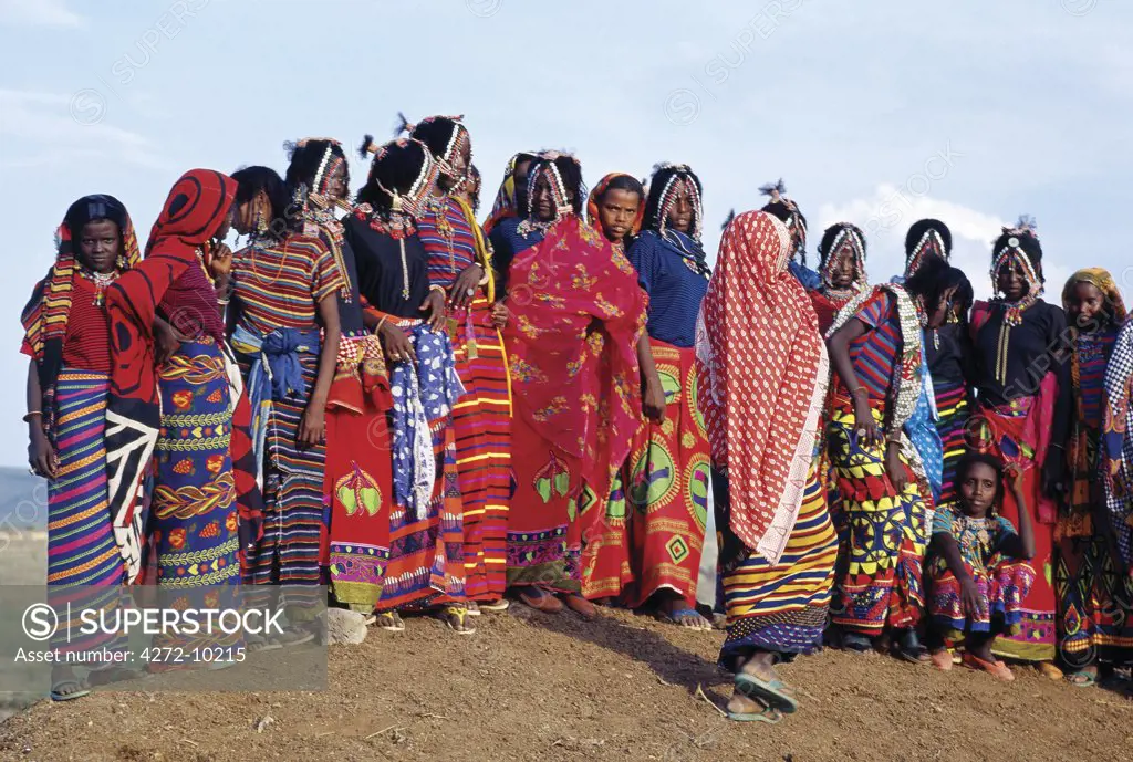 Afar girls wear brightly-coloured clothes and have their attractive hairstyles embellished with buttons and beads, which are typical of the young girls of their tribe. Proud and fiercely independent, the nomadic Afar people live in the low-lying deserts of Eastern Ethiopia.
