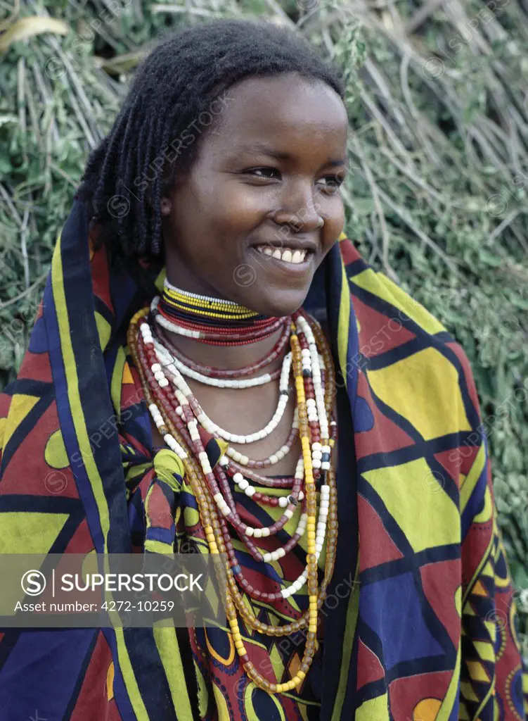 A pretty Borana girl at Mega in southern Ethiopia wears brightly coloured cotton cloth and numerous strings of beads.;The pastoral Borana live either side of the southern Ethiopian/northern Kenya border and form a large and important group of the Oromo-speaking cluster of tribes.