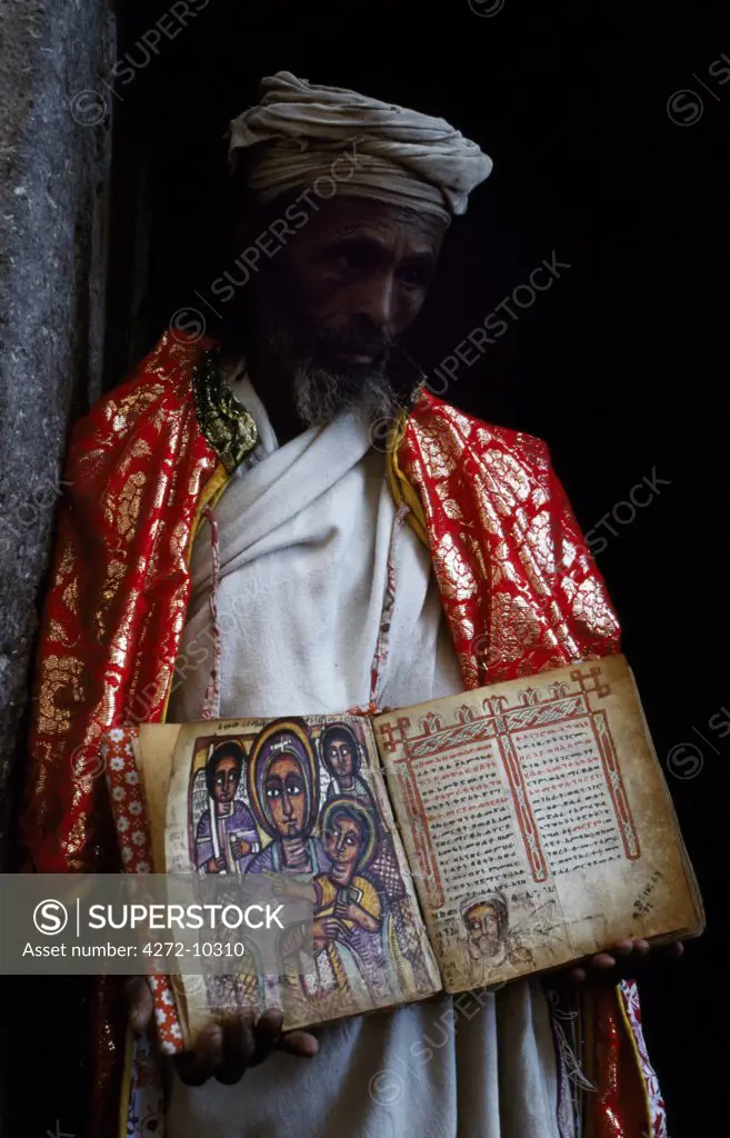 A priest holds one of the monastery's ancient illuminated texts.