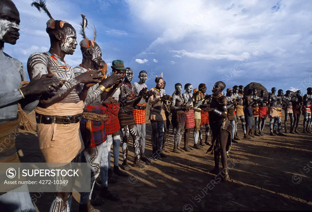 At a dance in the Karo village of Duss men clap as they sing at the beginning of a dance. A small Omotic tribe related to the Hamar, the Karo live along the banks of the Omo River in southwestern Ethiopia.  They are renowned for their elaborate body art using white chalk, crushed rock and other natural pigments.