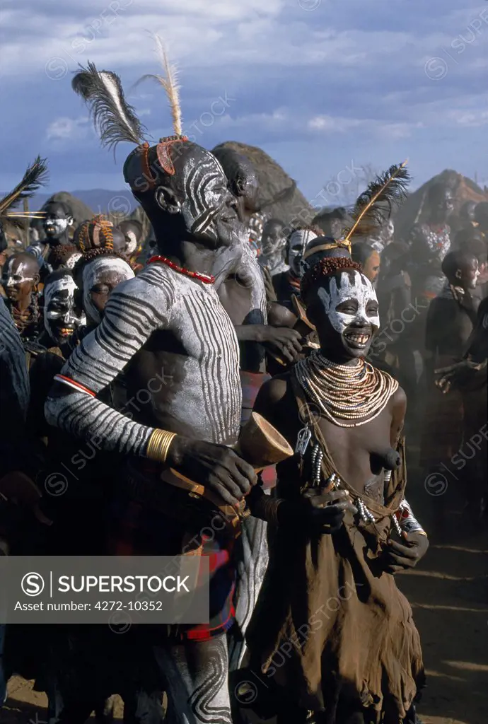Men and women dance together in the Karo village of Duss. A small Omotic tribe related to the Hamar, the Karo live along the banks of the Omo River in southwestern Ethiopia.  They are renowned for their elaborate body art using white chalk, crushed rock and other natural pigments.