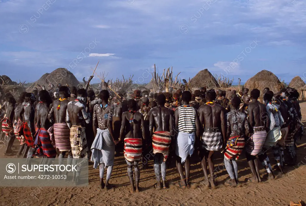 The men hold hands forming a circle within which the women dance  in the Karo village of Duss. A small Omotic tribe related to the Hamar, the Karo live along the banks of the Omo River in southwestern Ethiopia.  They are renowned for their elaborate body art using white chalk, crushed rock and other natural pigments.