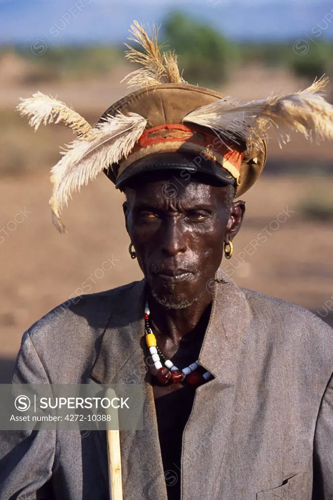 A tribal elder of the Nyangatom sits watching a dance.  He is wearing an Italian military hat left behind from the colonial era, which he has decorated with feathers for the dance.  The Nyangatom or Bume are a Nilotic tribe of semi-nomadic pastoralists who live along the banks of the Omo River in south-western Ethiopia.