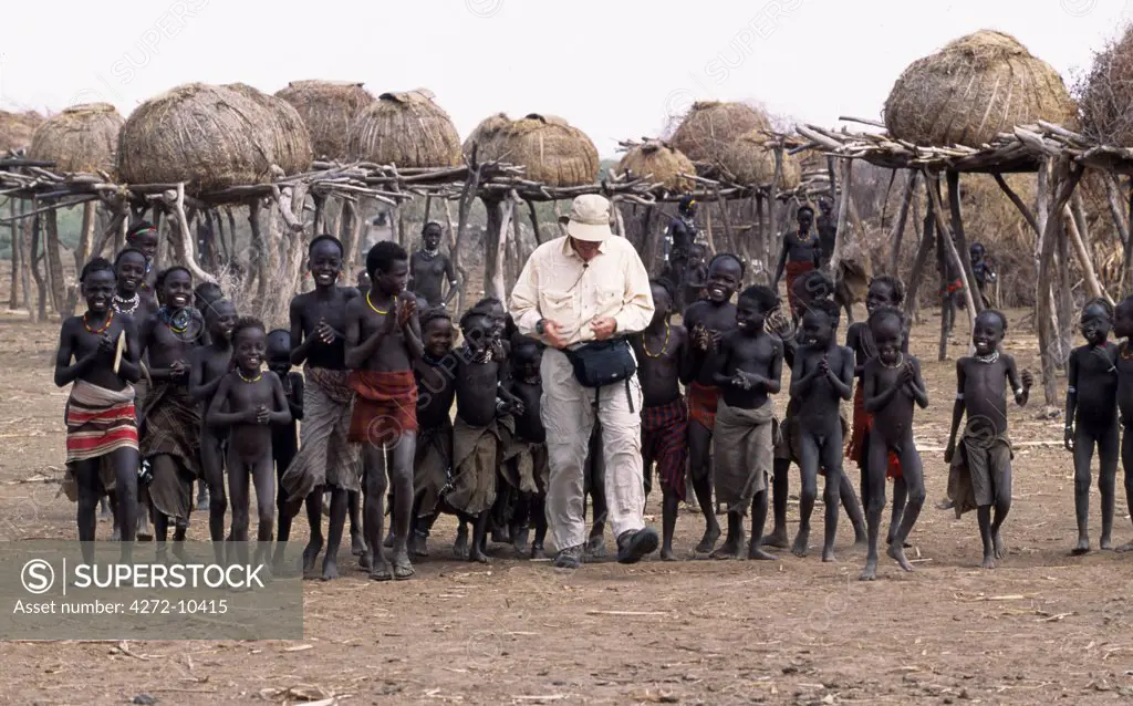A tourist accompanied by a retinue of children in a Dassanech settlement along the lower Omo River.  Much the largest of the tribes in the Omo Valley numbering around 50,000, the Dassanech (also known as the Galeb, Changila or Merille) and Nilotic pastoralists and agriculturalists.