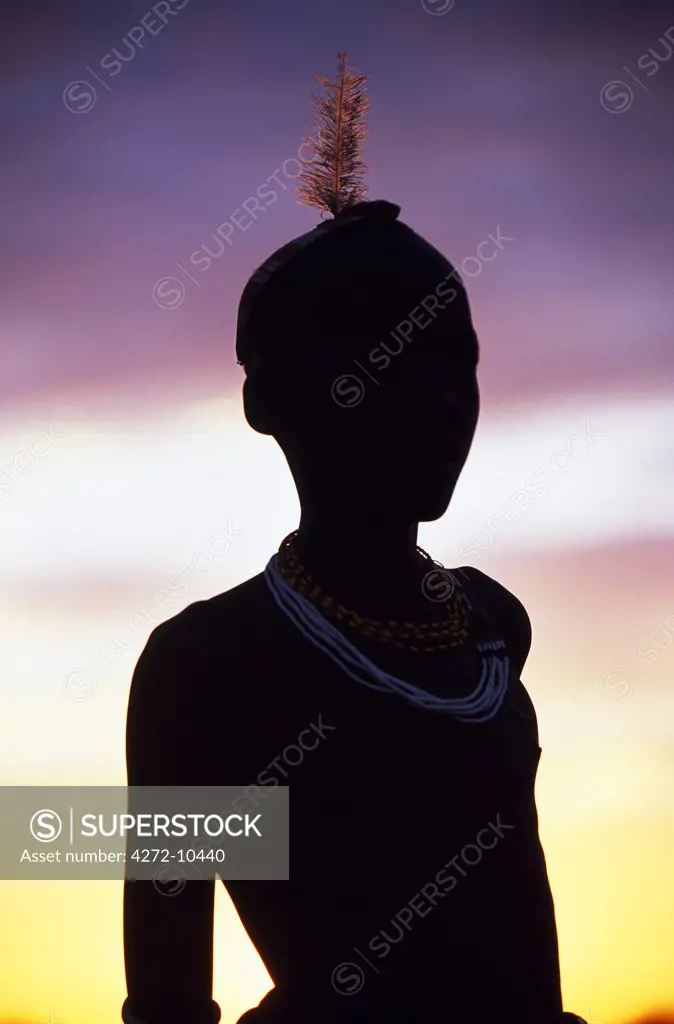 A young Dassanech boy silhouetted against the evening sky at his settlement alongside the Omo River. Much the largest of the tribes in the Omo Valley numbering around 50,000, the Dassanech (also known as the Galeb, Changila or Merille) are Nilotic pastoralists and agriculturalists.